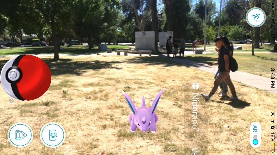A Pokemon creature, called a male Nidoran, appears in the new Pokemon Go game that is a smartphone app while in Merced's Courthouse Park, where about 50 people gathered to play in one afternoon on Monday, July 11, 2016. The free downloadable mobile app is an interactive game that forces players to travel outside their homes, into the real world to catch virtual critters. Players collect, evolve and battle their Pokemon with other real-world players.