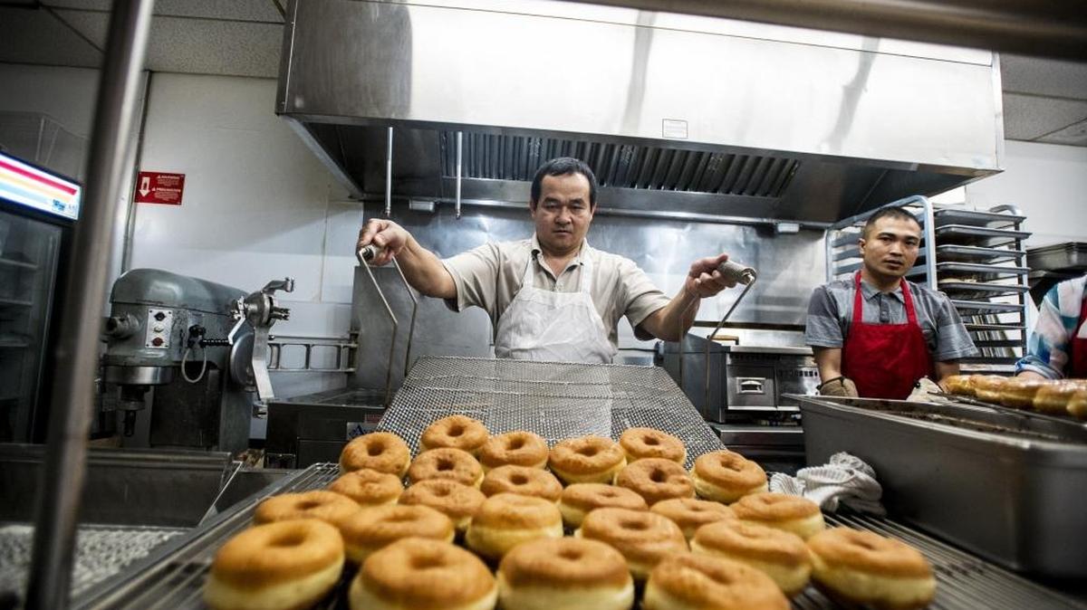 Doughnuts are removed from the fryer by owner Vannak Sao at Donut King’s at 260 W. Main St. in Merced, Calif., on Friday, June 3, 2016.