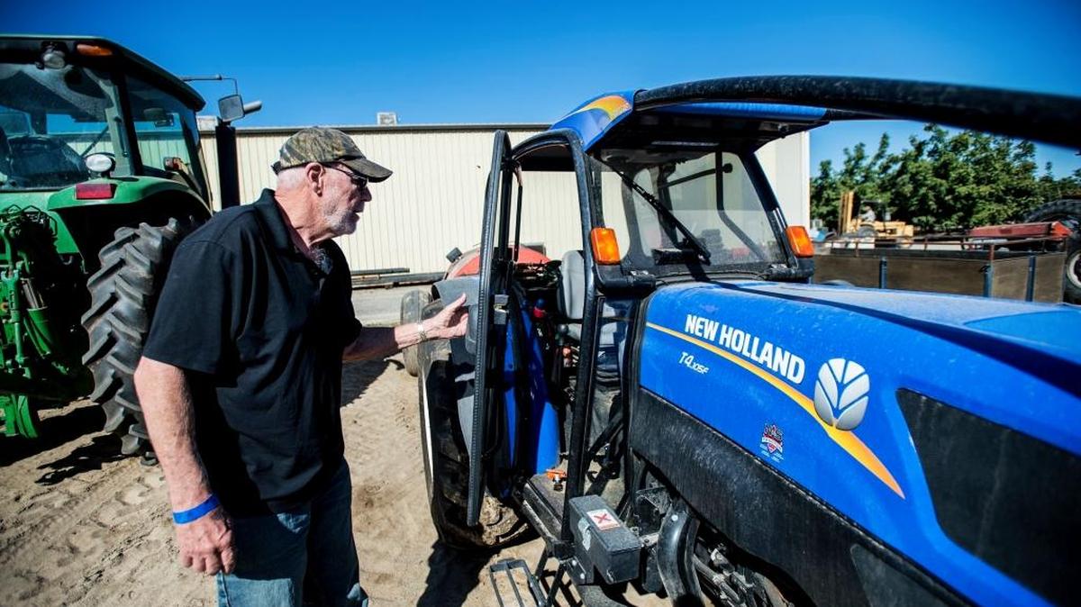 Bob Weimer, owner of Weimer Farms in Atwater, opens the door to an enclosed tractor cab used for the application of pesticides on crops in October 2015.