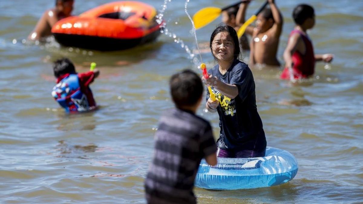 Pangkou Moua, 16, of Merced, sprays water at her brother Michael Moua, 7, at Lake Yosemite in Merced, Calif., on Saturday, June 17, 2017. According to the National Weather Service in Hanford, triple-digit highs are expected throughout the week.
