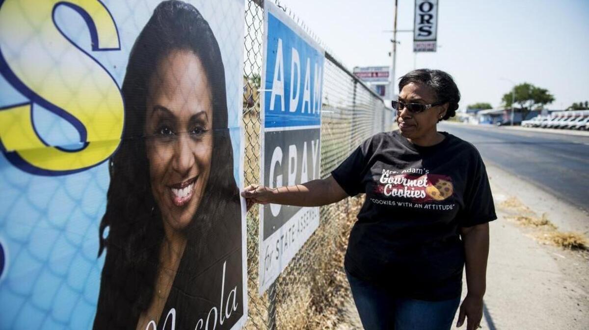 Merced County resident and Mayoral candidate, Necola Adams looks at the damage to one of her campaign signs near the intersection of Martin Luther King Jr. Way and West 13th Street in Merced, Calif., Tuesday, Aug. 23, 2016. According to Adams, six signs which all depict her face, have been damaged in recent weeks. With some of the signs being slashed and others burned, Adams is concerned the damage to her signs may be racially motivated.