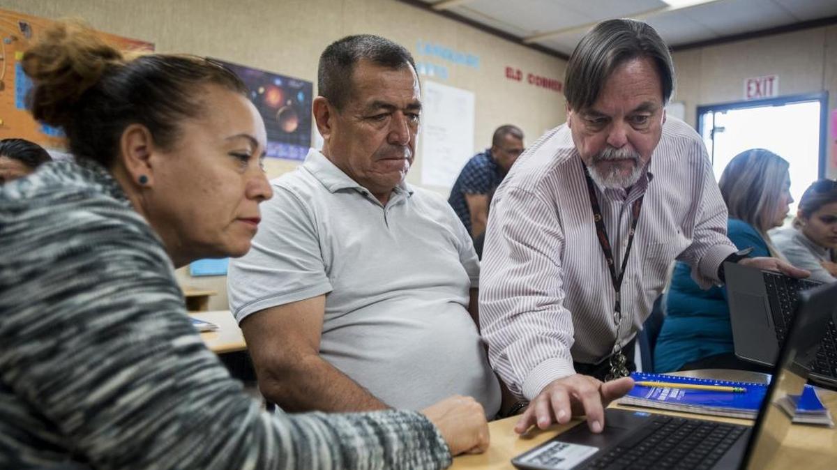 Class instructor Norman Martin, 63, of Merced, right, assists Livingston residents David Martinez, 56, center, and Rosa Areyan, 52, left, during a Merced Adult School citizenship class held at Campus Park Elementary School in Livingston, Calif., on Tuesday, April 25, 2017. The class prepares the students for the naturalization process to become a United States citizen.