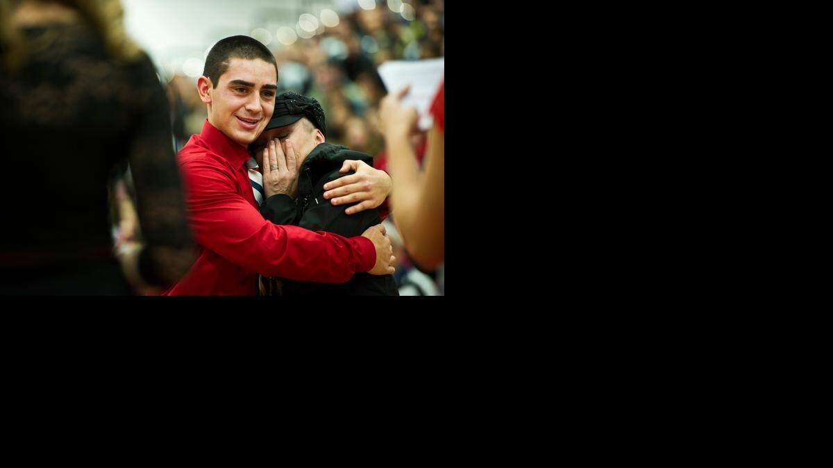 Darlene Neves of Los Banos, right, wipes tears from her eyes while receiving a hug from nephew Jovian Soto, left, an Atwater junior upon learning she was given certificates to a spa and restaurant during Atwater High School’s “Miracles Do Happen” assembly Dec. 12. Neves is a cancer patient.
