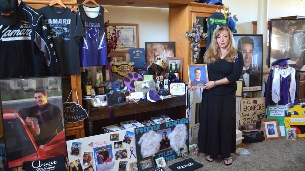 Francine Salazar Turner stands in front of a collection of photos, clothing and other memorial items in remembrance of her son, Tyler Turner, on Tuesday. The memorial was set up by Salazar Turner in remembrance of her son after he died in a skydiving accident Aug. 6.