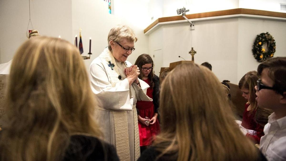 Pastor Dorothy Lindstrom says a prayer with children during Christmas Eve service at Shepherd of the Valley Lutheran Church in Merced on Saturday. The service concluded with a candlelit rendition of “Silent Night.”