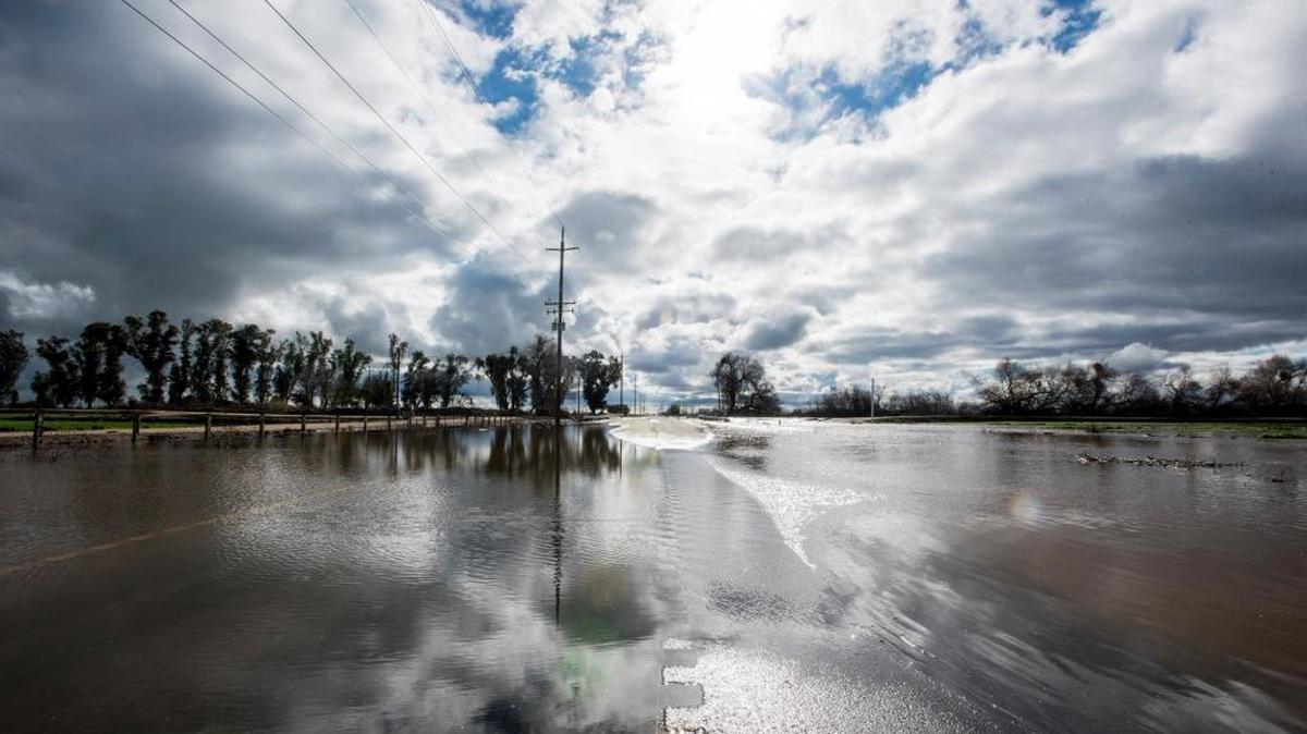 The Mariposa Creek overflows its banks and floods a section of Highway 59 in Merced County on Jan. 12. Storm runoff from the creek is used to replenish groundwater at the El Nido recharge basin.
