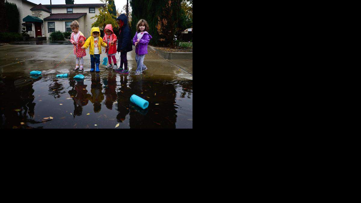 
Alexander Street Montessori School pupils float boats made from foam swimming noodles along East Alexander Avenue in Merced on Tuesday.
