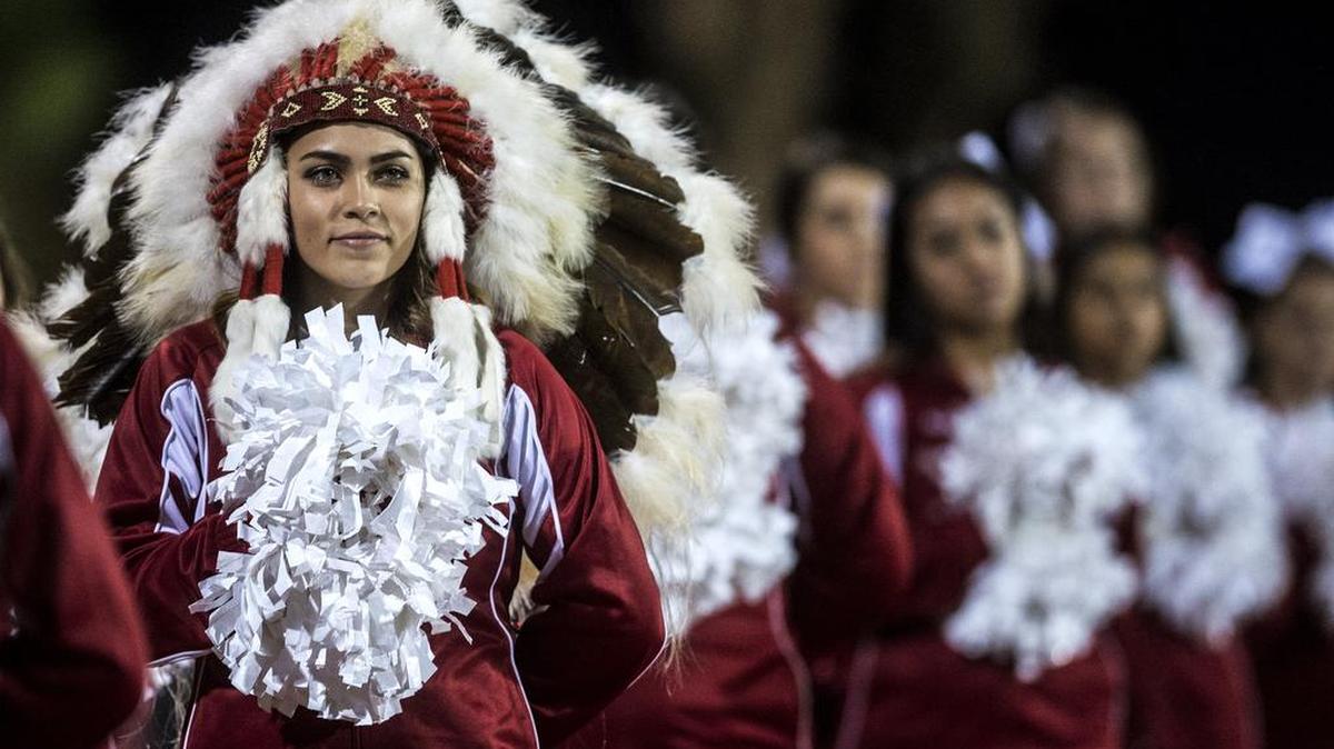 Chowchilla senior cheerleader Madison Robinson wears a Native American headdress during the Southern California Regional IV-AA Bowl Championship game against Fairfax at Chowchilla High School in Chowchilla on Dec. 12, 2015. The Redskins beat the Lions 28-16. Chowchilla is changing its mascot from the Redskins to the Tribe.