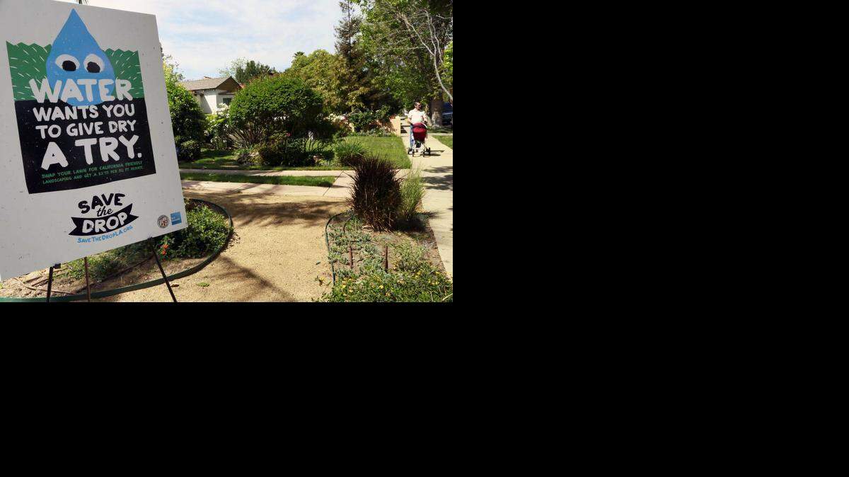 
A sign encouraging people to save water is displayed at a news conference in Los Angeles last week. A new report says that the drought is unlikely to have a significant economic impact. That could change if the drought drags on, it said.
