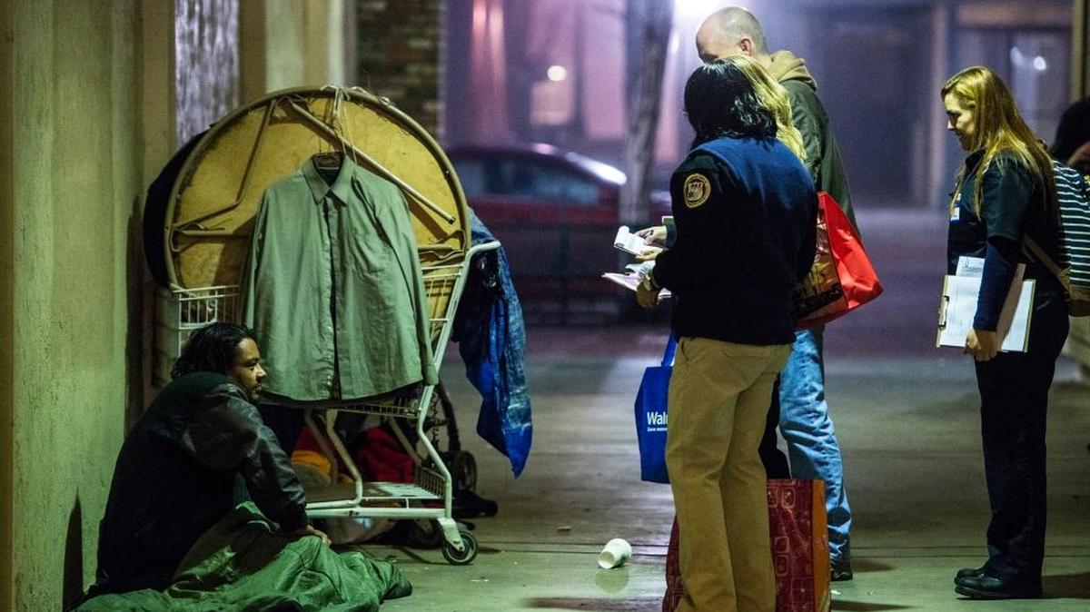A group of Riggs Ambulance Service volunteers, joined by Merced City Manager Steve Carrigan, stop to speak with a homeless man during the 2016 Merced City and County Continuum of Care Homeless Count in Merced, Calif., in January.