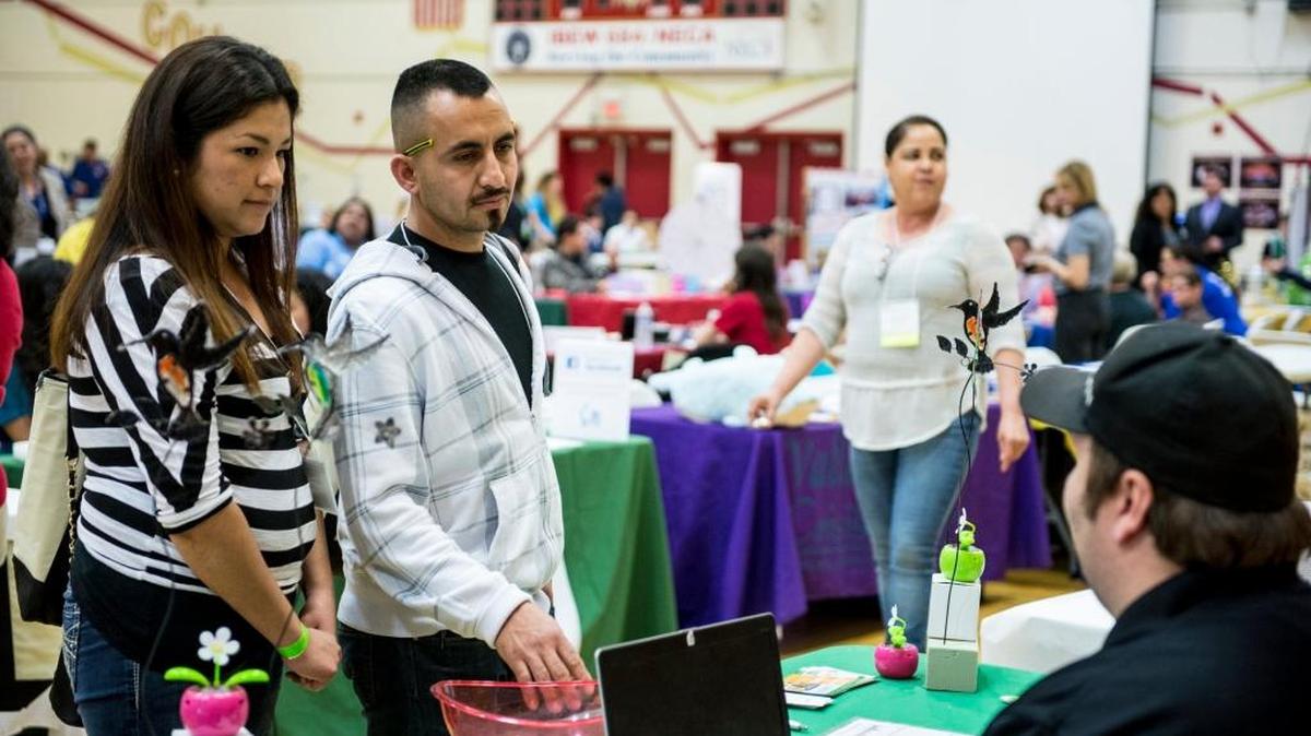 Mayra and Elizandro Gomez of Livingston speak with Morris Tolmachoff of Solar City, right, during the Merced County Parent Institute conference at Golden Valley High School in Merced on Feb. 27, 2016.