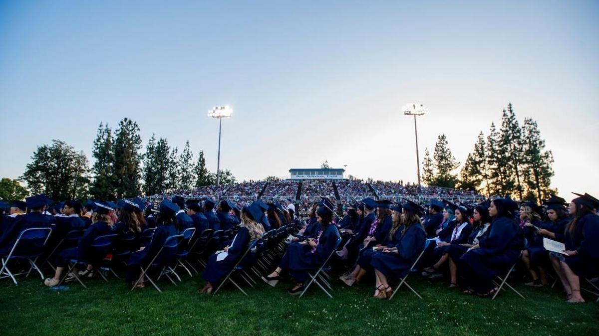 Merced College graduates listen to speakers during the Merced College graduation ceremony at Stadium ’76/Don Odishoo Field on the campus of Merced College in Merced, Calif., Friday, May 27, 2016.