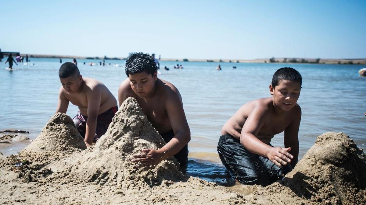 From left, Luis Diaz, 13, Jose Fuentes, 12, and Ralph Diaz, 13, all of Merced, play in the sand at Lake Yosemite on Memorial Day 2015. The unofficial start of summer has health experts advising people to protect their skin from sunburn in order to lower the chances of developing skin cancer.