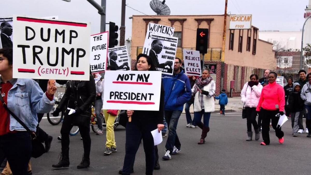A woman carries a sign reading “Not my president” in protest of President-elect Donald Trump during Merced’s annual Martin Luther King Jr. Day march on Monday.