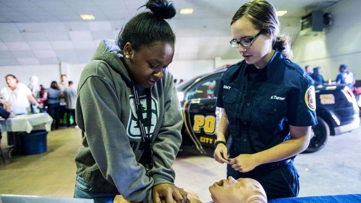 Yosemite High School student Ariajh Hicks, 16, left, learns the proper technique for chest compressions from Riggs Ambulance Service EMT Bryanna Turner, 19, of Merced, right, during the 2015 Merced County Office of Education’s annual Career Industry Day at the Merced County fairgrounds in Merced, Calif.