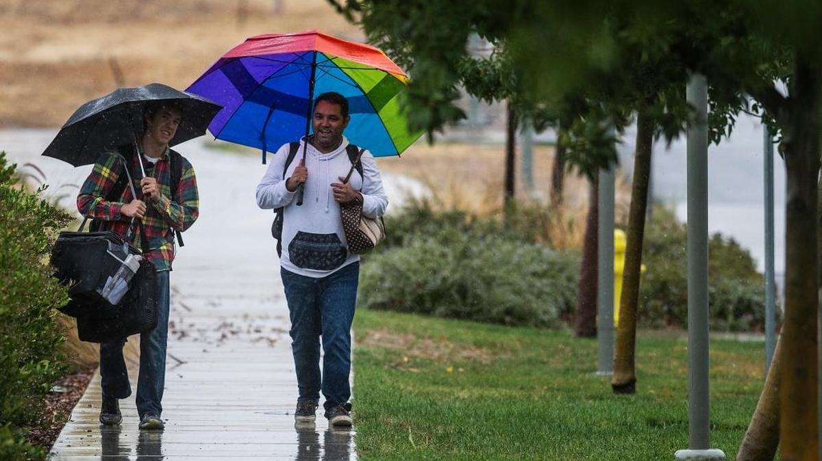 UC Merced students Eddie Gibb, 25, left, and Asa Gardner, 36, right, walk on the rainy campus on Monday, Nov. 2, 2015.