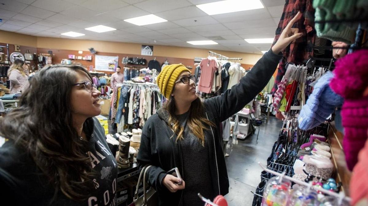 Merced residents Kaitlin Hanshew, 22, left, and Tori Rowe, 21, right, look at a wall of hats while shopping at Envy Fine Clothing located at 3564 G Street, during Small Business Saturday in Merced, Calif., on Saturday, Nov. 26, 2016.