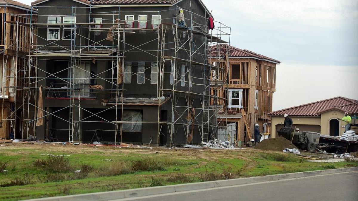 Construction crews work on houses going up in a subdivision near Cardella Road and G Street in December, 2018.