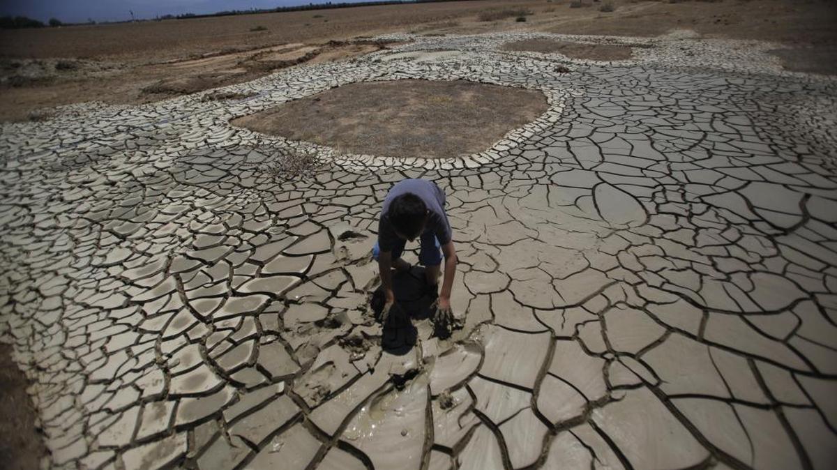 Brandon Arthur, 10, tries to get out of muddy tailings left by his father’s water well drill site on an orange grove farm in Terra Bella.