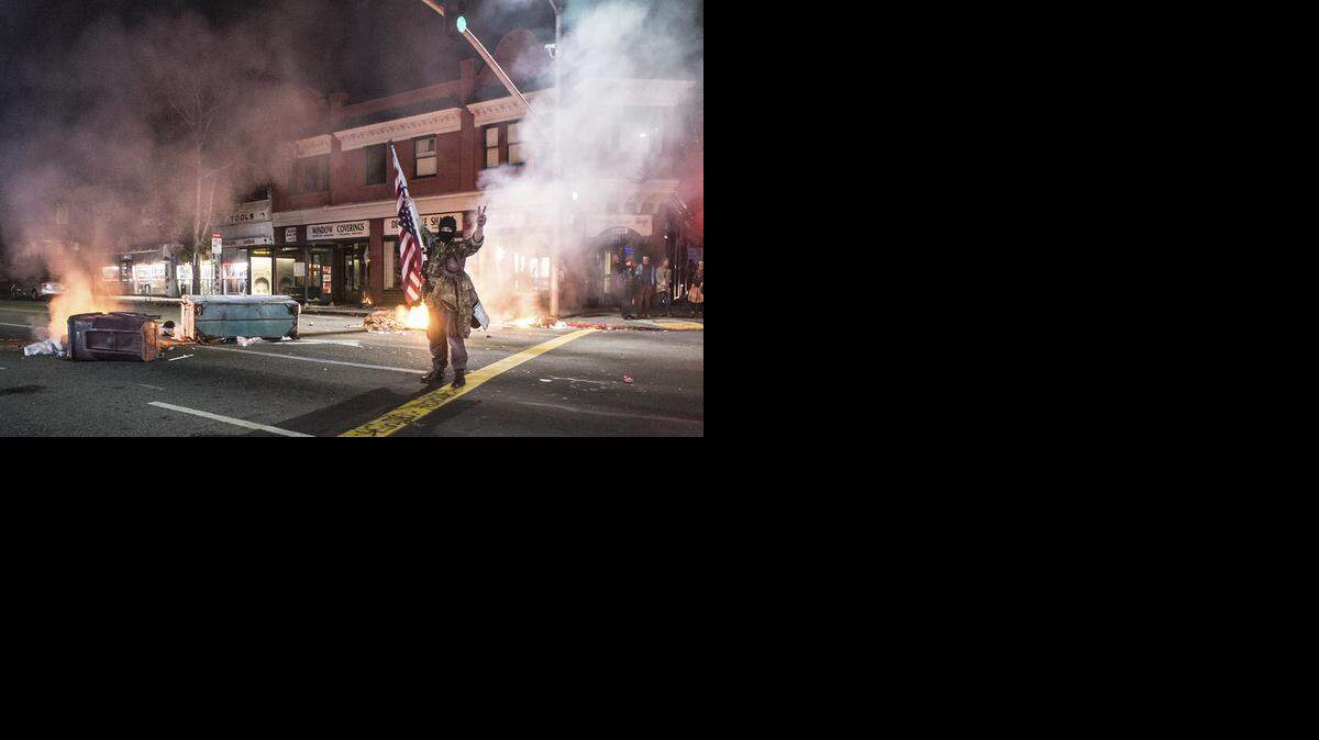 
A Berkeley protester stands in the wreckage of Sunday’s demonstration against police killings in Missouri and New York. 
