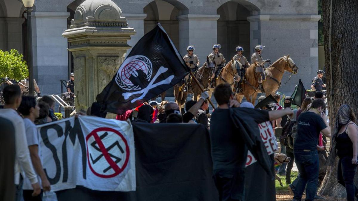 Mounted police officers stand guard Sunday at the state Capitol, where clashes between neo-Nazis and anti-fascist protesters injured at least 10.