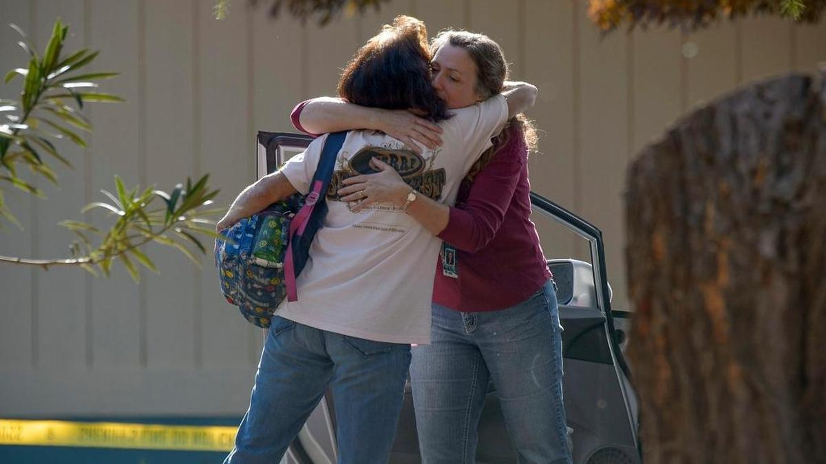 Two unidentified school officials embrace on the grounds of the Rancho Tehama Elementary school, one scene in Tuesday’s shootings; though a student was shot, no one was killed at the school.
