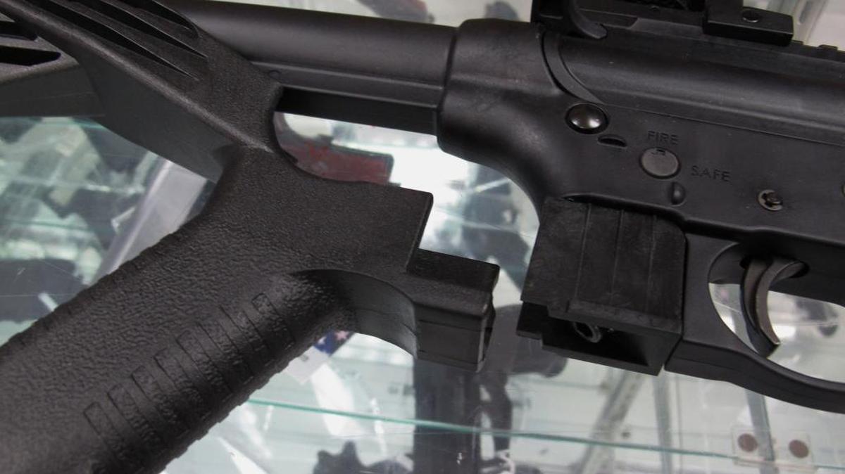 A "bump stock” sits next to a disassembled .22-caliber rifle at North Raleigh Guns in Raleigh, N.C.