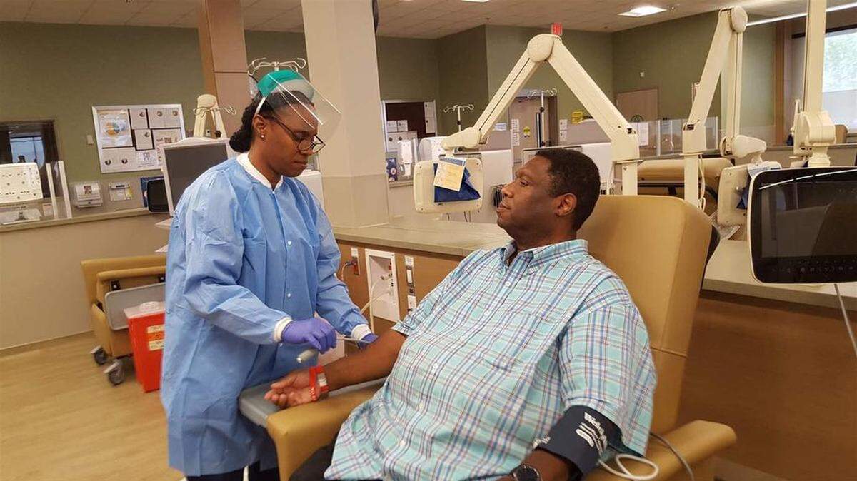 Dialysis technician Audrey Thomas demonstrates how kidney dialysis is set up on patient DeWayne Cox at a new Southern California clinic. Proposition 8 on the Nov. 6 ballot would limit clinic profits.