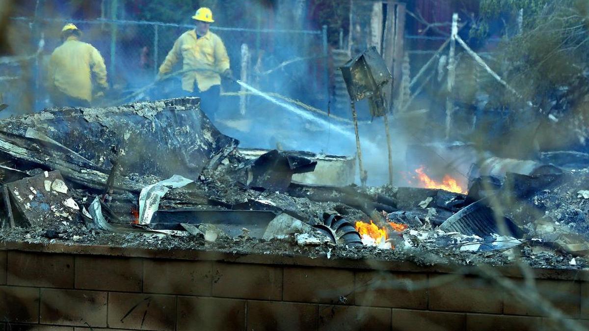 Firefighters battle a structure fire after a wildfire swept through an area near Bakersfield last week. California’s state and local firefighters have some of the state’s highest and most expensive pension benefits.