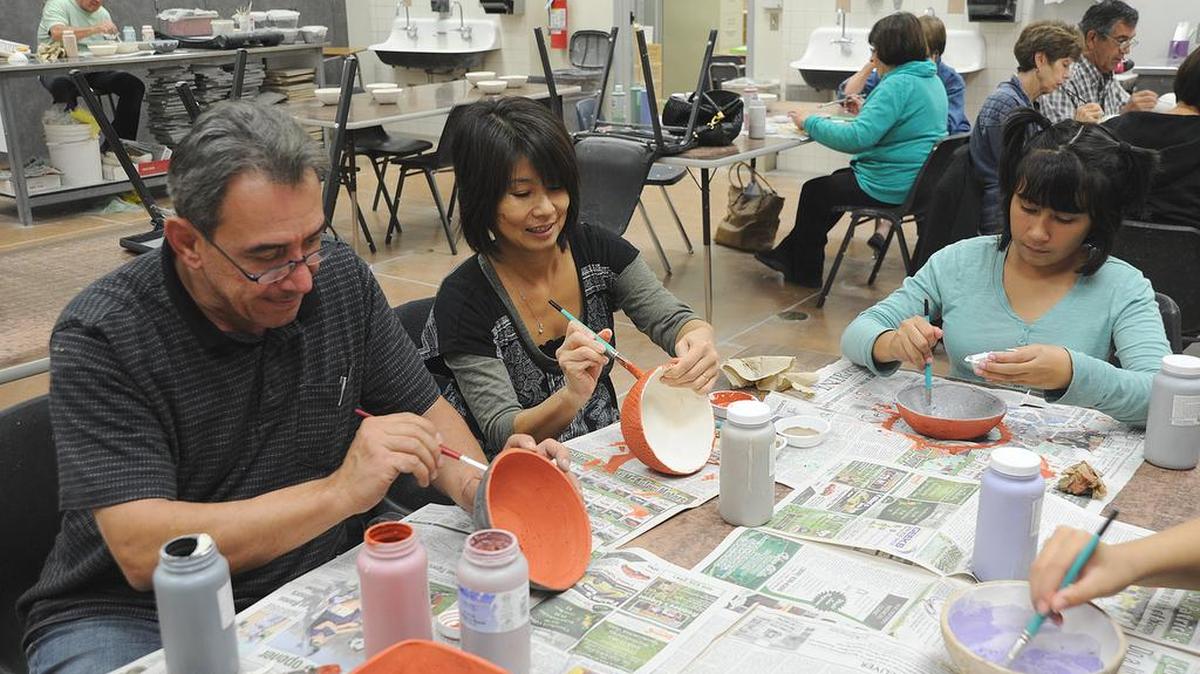 Members of the Zako family, from left, Joseph, Emi and Faith paint bowls at Los Banos Junior High School for the Empty Bowls event at the Ted Falasco Arts Center.