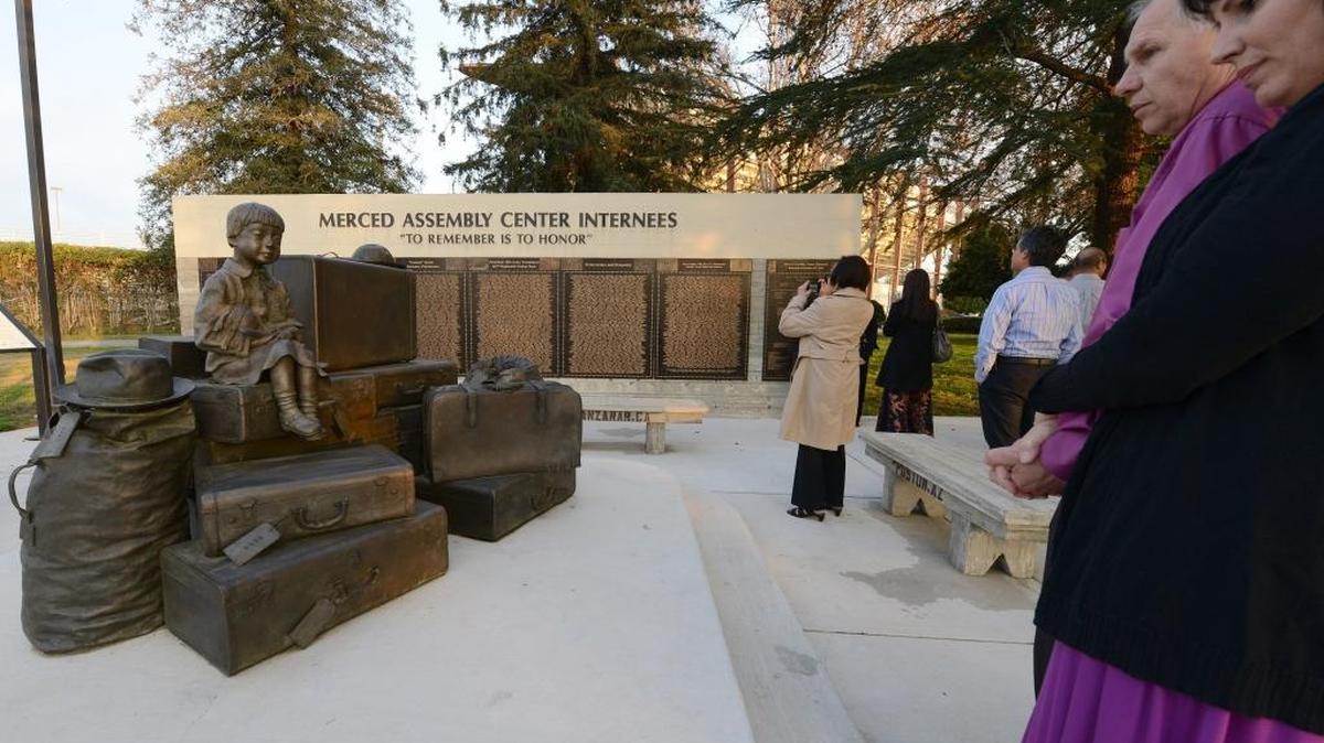 The designer and sculptor of the statue of a Japanese American girl sitting on suitcases, Dale Smith, views his work with his wife, Pam, at the Merced Assembly Center Internees memorial during the Merced-Livingston chapter of the Japanese American Citizens League annual remembrance dinner held at the Merced County Fairgrounds in 2013. The event remembers the signing of Executive Order 9066 on Feb. 19, 1942 by President Franklin D. Roosevelt, which ordered 120,000 Japanese Americans into internment camps during World War II. It also remembers that the fairgrounds in Merced were one of 21 assembly centers where Japanese Americans were sent before being taken to an internment camps throughout the United States.