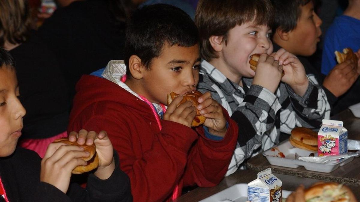 Los Banos Elementary students dig in during lunch. New federal rules require they each get a piece of fresh fruit and a vegetable each day.