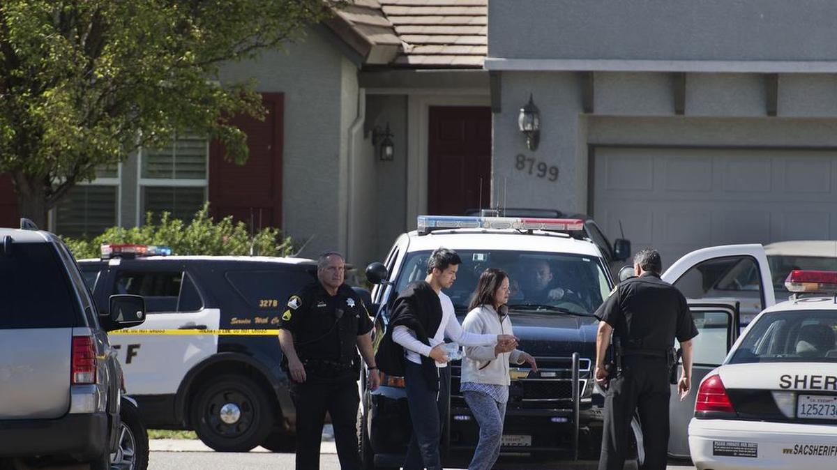 Sacramento County sheriff’s deputies escort two people from a crime scene where three men were shot on April 28, 2016, in Sacramento. All three men died.