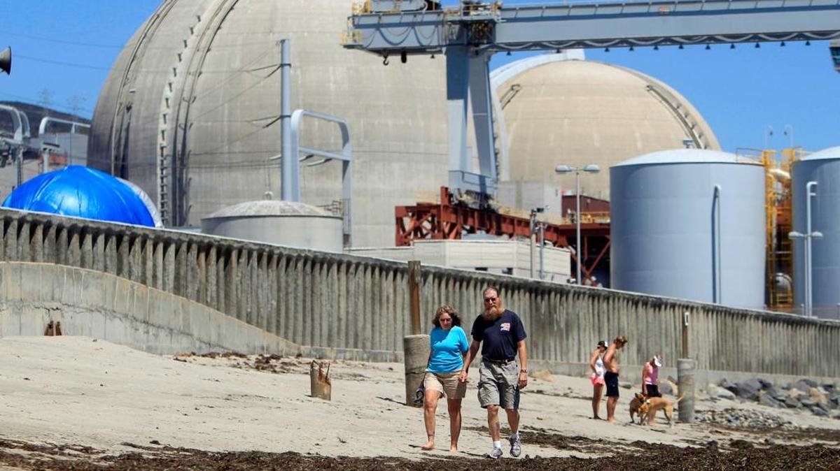 File photo of people walking past the shuttered San Onofre nuclear power plant in San Clemente.