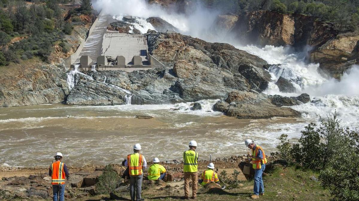Water cascades down and around the collapsed main spillway of Oroville Dam on Friday after the Department of Water Resources resumed its use after three weeks of debris clearance. Gov. Jerry Brown is seeking federal aid to repair the damaged spillway and for other infrastructure projects.