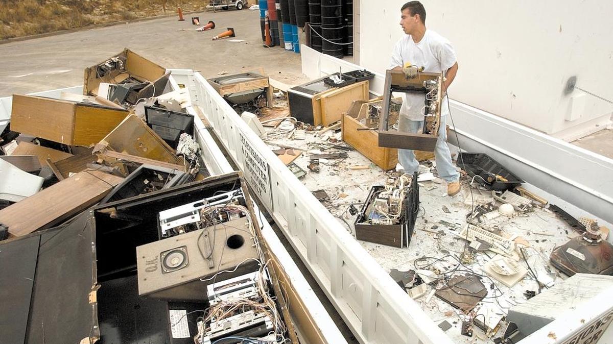 A worker watches old TVs move down a conveyor on their way to being recycled. Unfortunately, there’s no market for the lead glass from old TVs, but that doesn’t stop Californians from paying a fee when they purchase electronics.