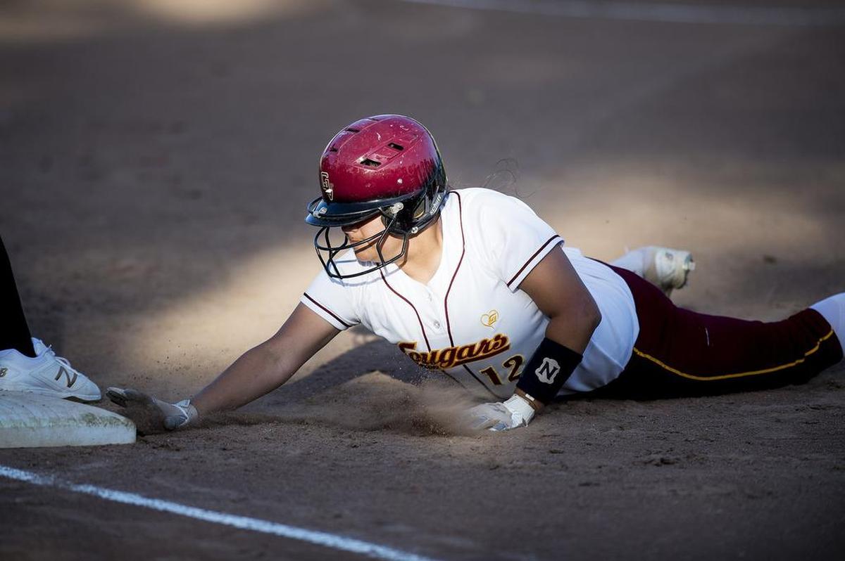 Golden Valley junior Maddie Martinez (12) dives safely back to first base during a game against Merced at Joe Herb Park in Merced Calif., on Thursday, April 12, 2018. The Cougars beat the Bears 3-2.