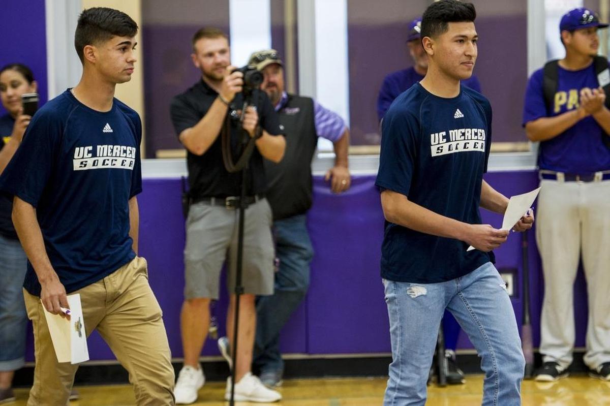 Livingston High School's Francisco Lopez, left, and Marco Sobrevilla, right, are applauded by fellow students as they enter the schools gymnasium for a ceremony following the signing of their letters of intent to play soccer at the University of California, Merced at Livingston High School in Livingston, Calif., on Tuesday, April 17, 2018.