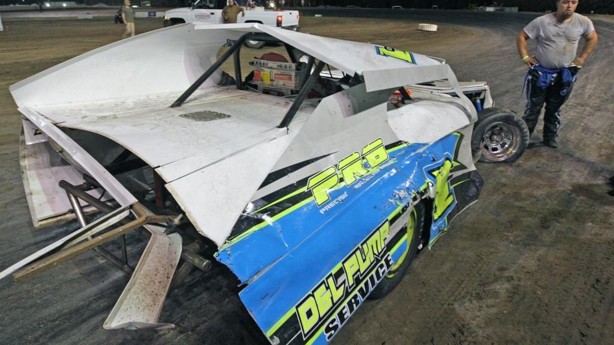 Merced Speedway - Tim Cecil examines the damage to his IMCA Modified stock car after a last lap crash in July. (Photo by Mike Adaskaveg)
