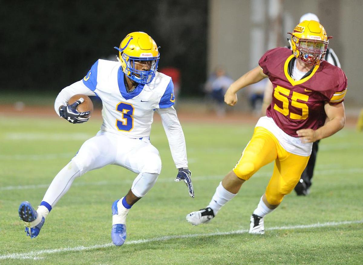 Dos Palos running back, Tyree Martin, left, tries to run away from Los Banos defender, Ryan Subia, Friday night, Aug. 23, 2019 at Loftin Stadium in Los Banos.