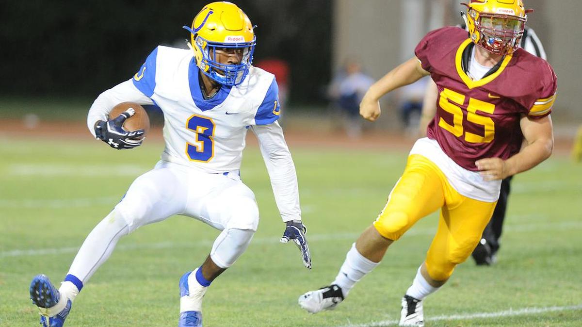 Dos Palos running back, Tyree Martin, left, tries to run away from Los Banos defender, Ryan Subia, Friday night, Aug. 23, 2019 at Loftin Stadium in Los Banos.