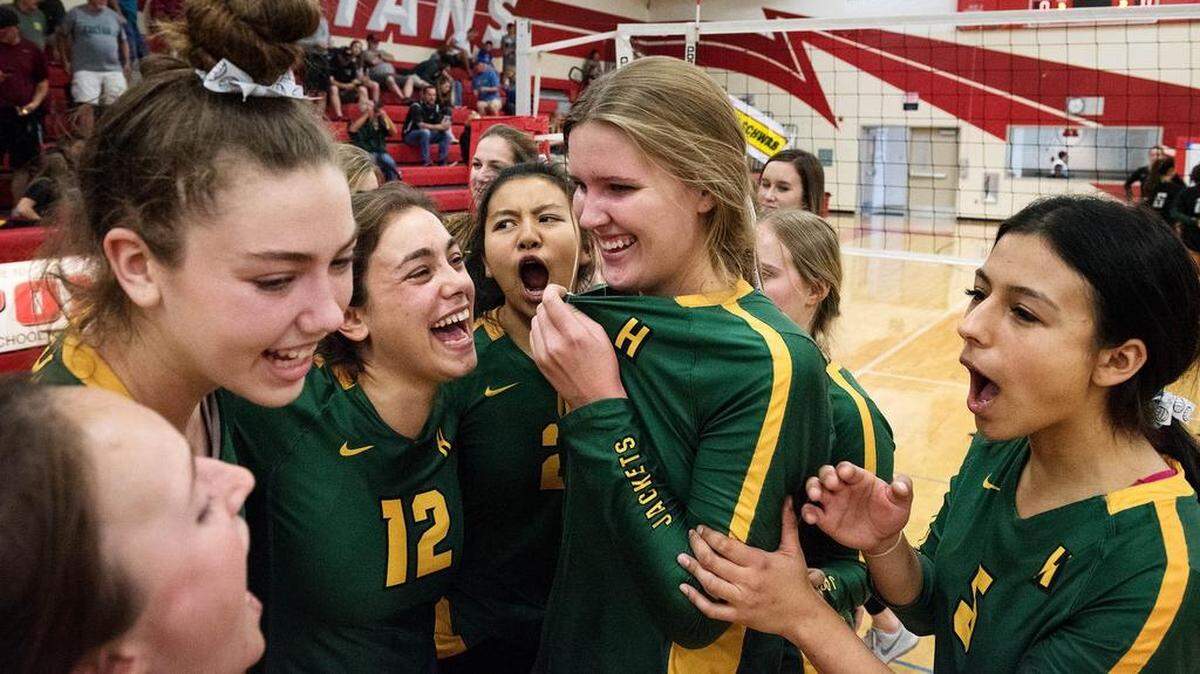 Hilmar players Olivia Peterson, middle, Makayla Fontes (12), Alondra Huerta, right, and Mikela Labno, left, celebrate their 3-0 section title victory over Colfax with their teammates in Ripon, Calif., Saturday, Nov. 3, 2018.
