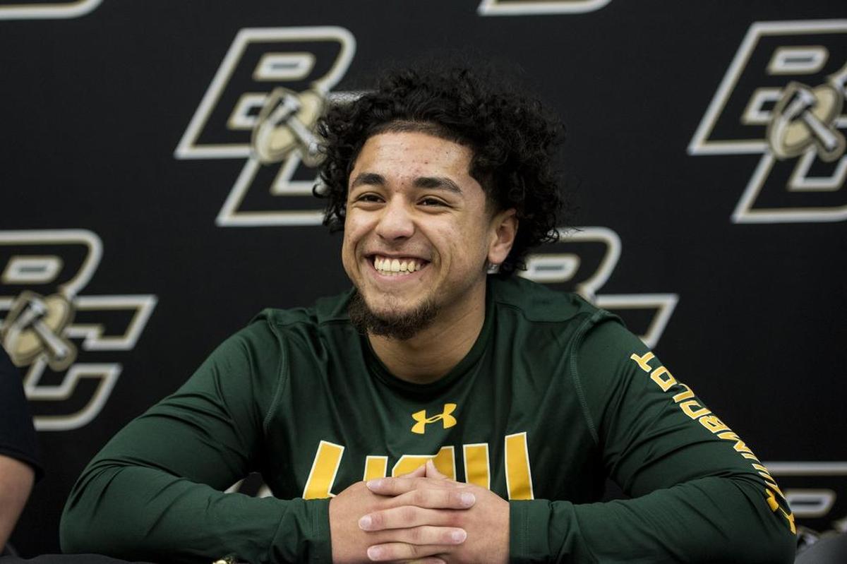 Buhach Colony senior Christian Quirarte smiles at friends before signing his letter of intent to attend Humboldt State University, at Buhach Colony High School in Atwater, Calif.,. on Thursday, March 8, 2018.