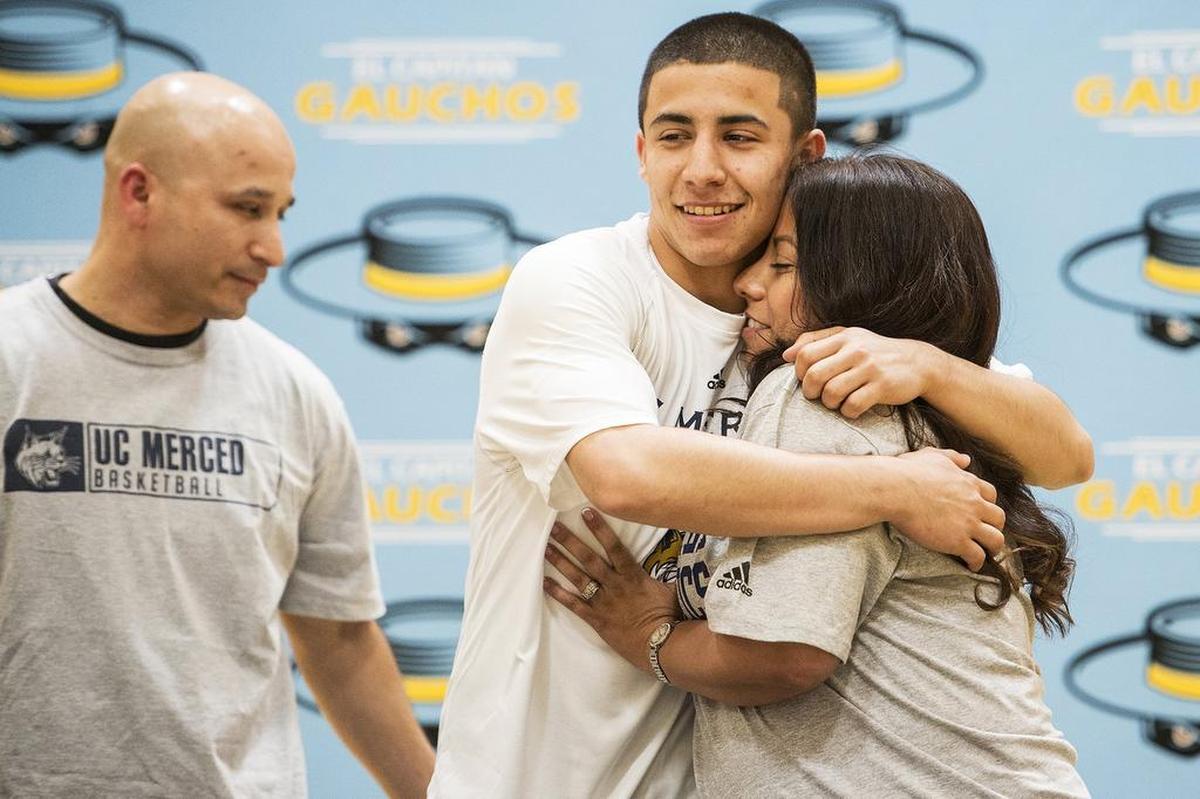 El Capitan senior Angel Serena hugs his mother Monica after signing his letter of intent to attend and play basketball for the University of California, Merced, during a ceremony at El Capitan High School in Merced, Calif., on Friday, April 27, 2018.