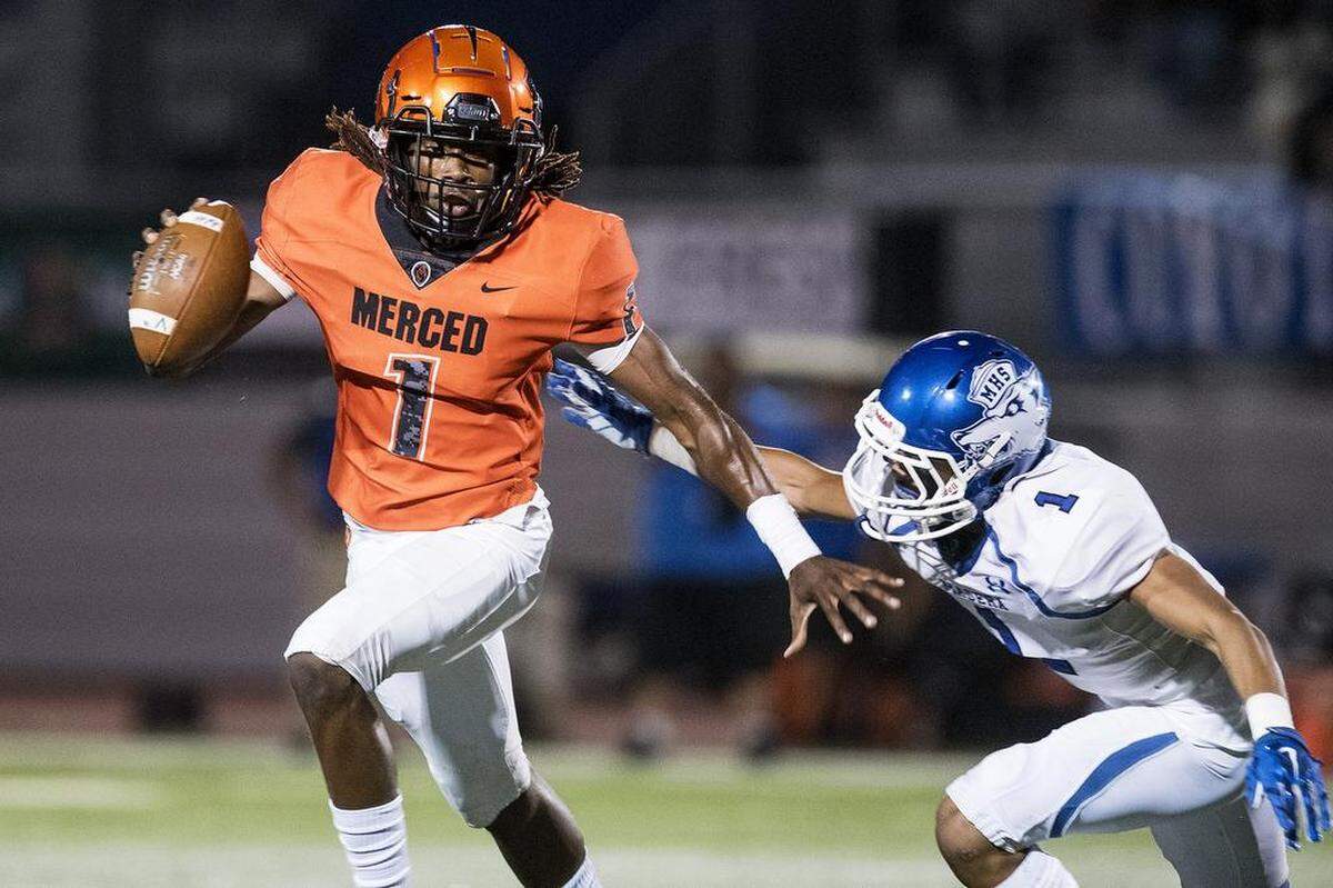 Merced senior quarterback Dhameer Warren (1) scrambles out of the pocket during a game against Madera at Veterans Stadium on the campus of Golden Valley High School in Merced, Calif., on Friday, Sept. 7, 2018. The Bears beat the Coyotes 63-35.