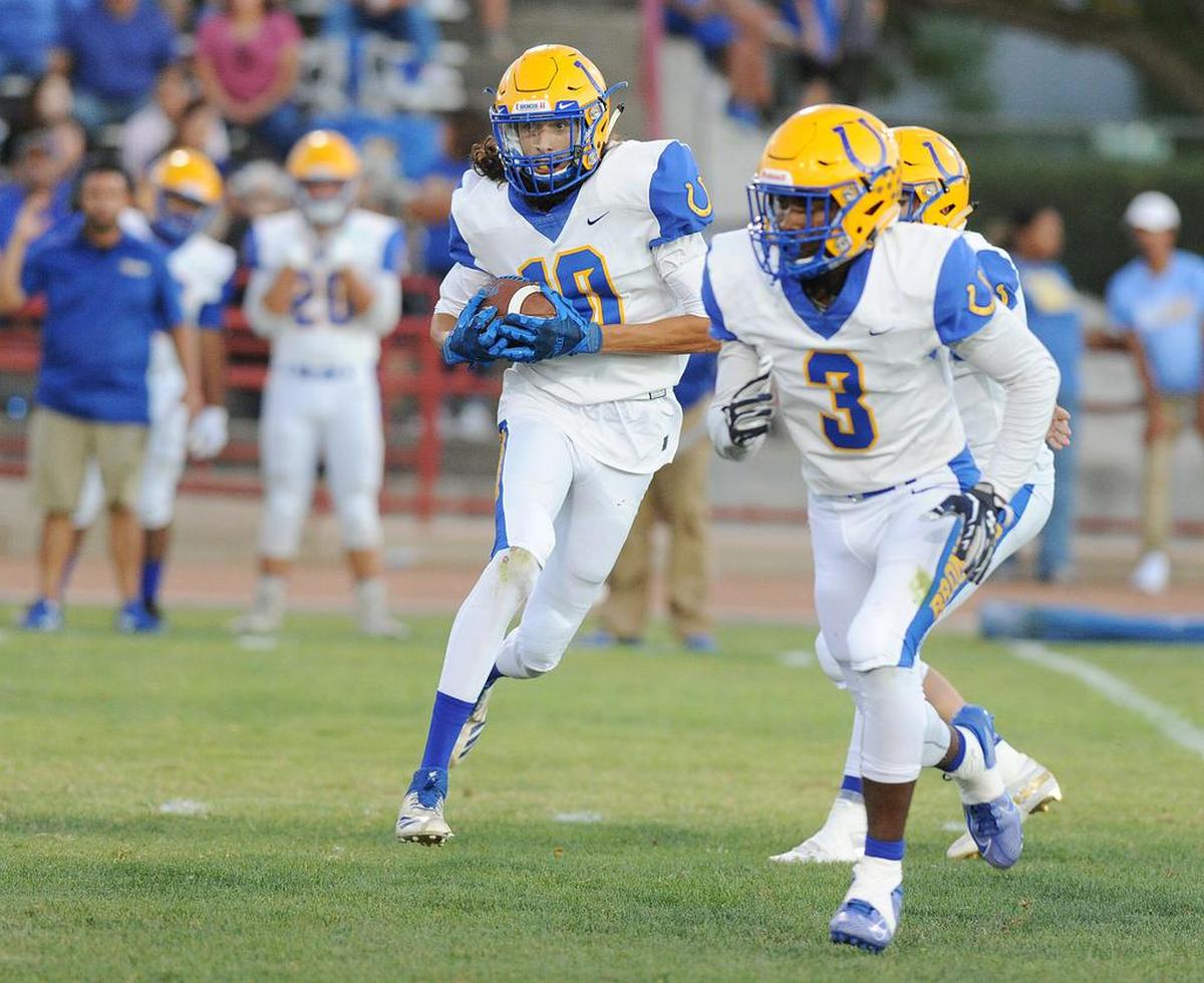 Dos Palos High School wide receiver, Zane Merrell, left, runs with blocking assistance from Tyree Martin against Los Banos High School Friday night, Aug. 23, 2019 at Loftin Stadium in Los Banos.