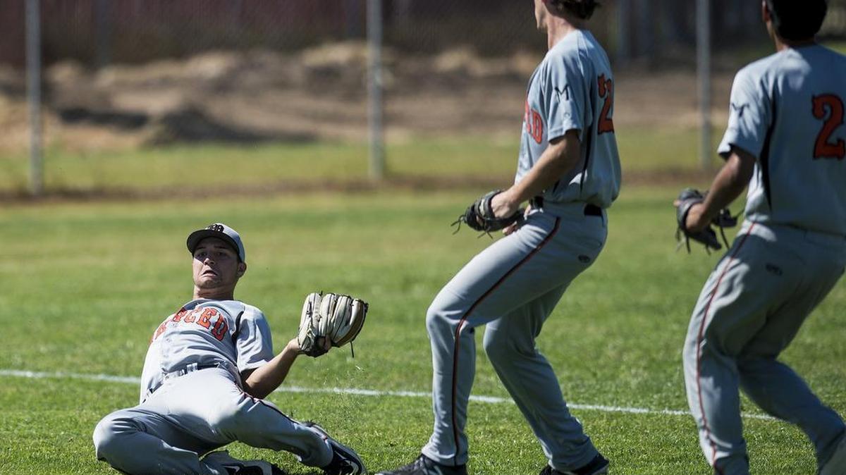 Merced senior Garrett Stappenbeck (21) makes a sliding catch for an out in foul territory during a game against Buhach Colony at Buhach Colony High School in Atwater, Calif., on Saturday, April 21, 2018. The Thunder beat the Bears 7-0.