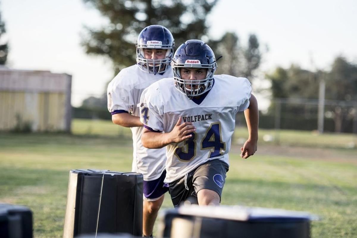 Livingston’s Adam Madrid runs drills during football practice at Livingston High School in Livingston, Calif., on Wednesday, July 25, 2018.
