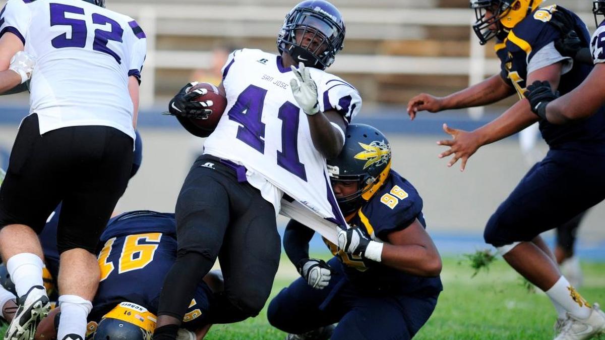 Merced defensive lineman Terris Evans (96) grabs a fist full of jersey to bring down San Jose's Isaiah Feaster (41), during a game earlier this year. The Blue Devils defense has helped the team start out 3-0 for the first time since 1995.