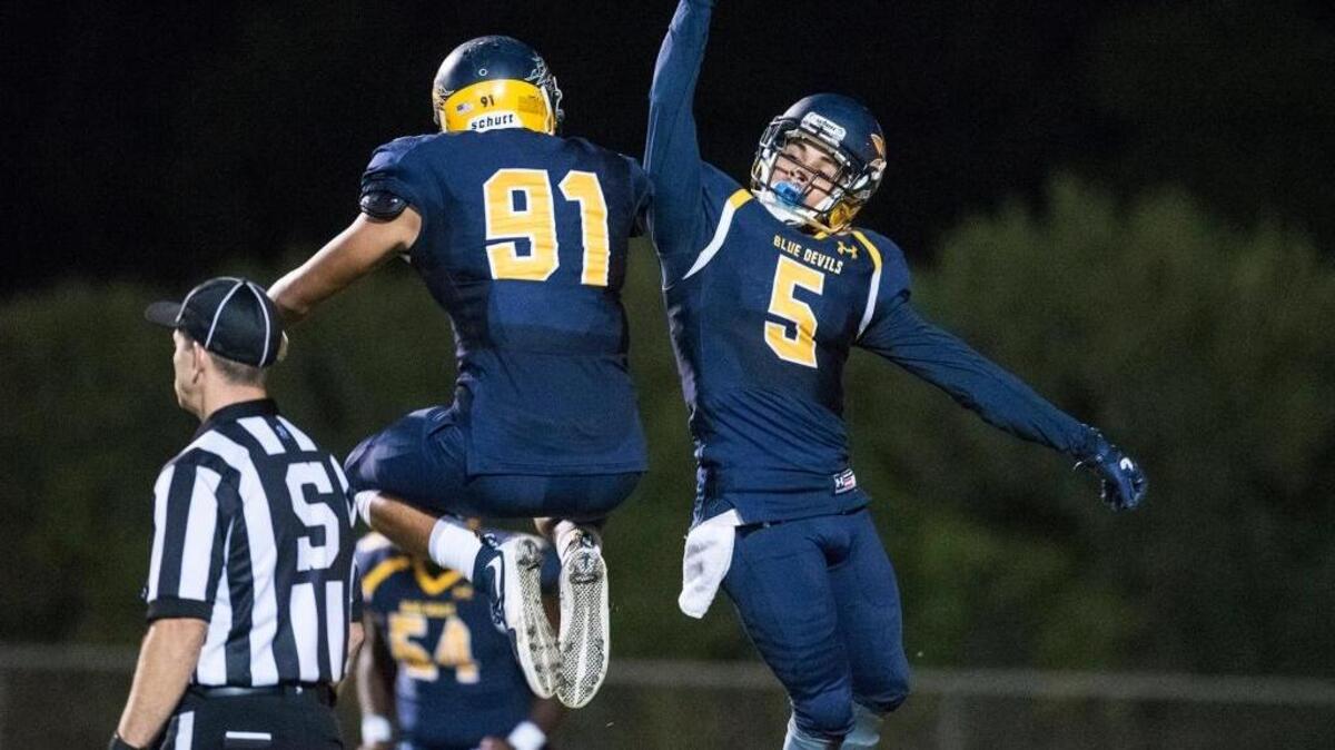 Merced College sophomore Nick Cook (5) celebrates with freshman David Perales (91) after scoring a touchdown during a game against Hartnell at Stadium '76 in Merced, Calif., on Saturday, Oct. 14, 2017. The Blue Devils beat the Panthers 33-28.